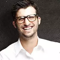 A man with glasses wearing a white shirt